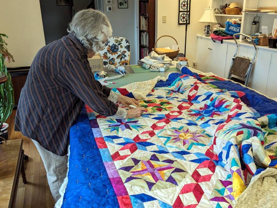 Mary with quilt on ping-pong table